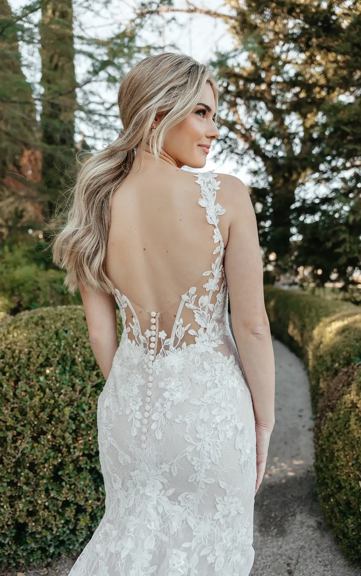 model is wearing an open back wedding dress