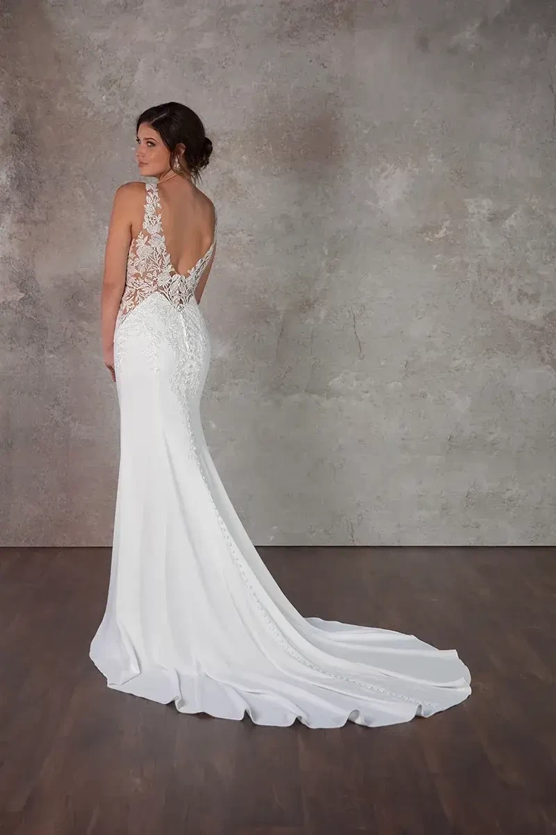 model is wearing a matte lace sleeveless bridal gown with an open back