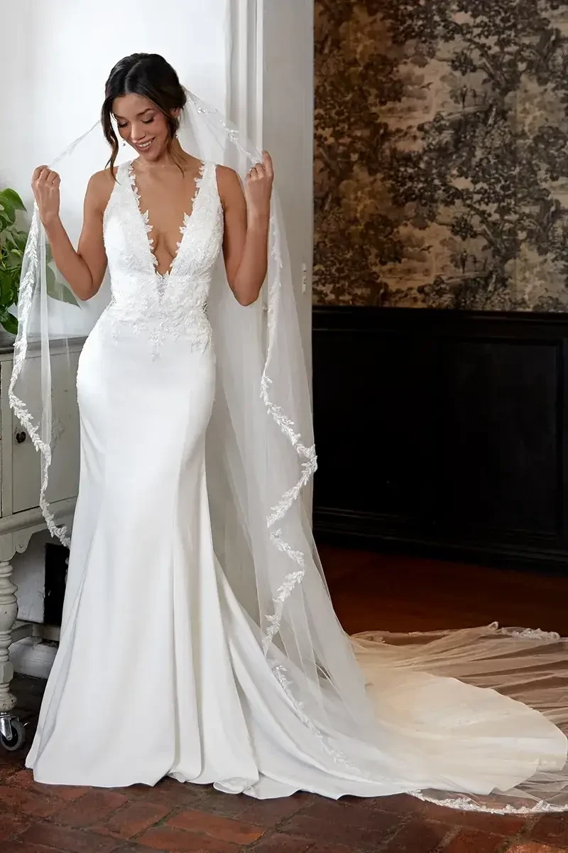 model is wearing a matte lace sleeveless bridal gown with an open back