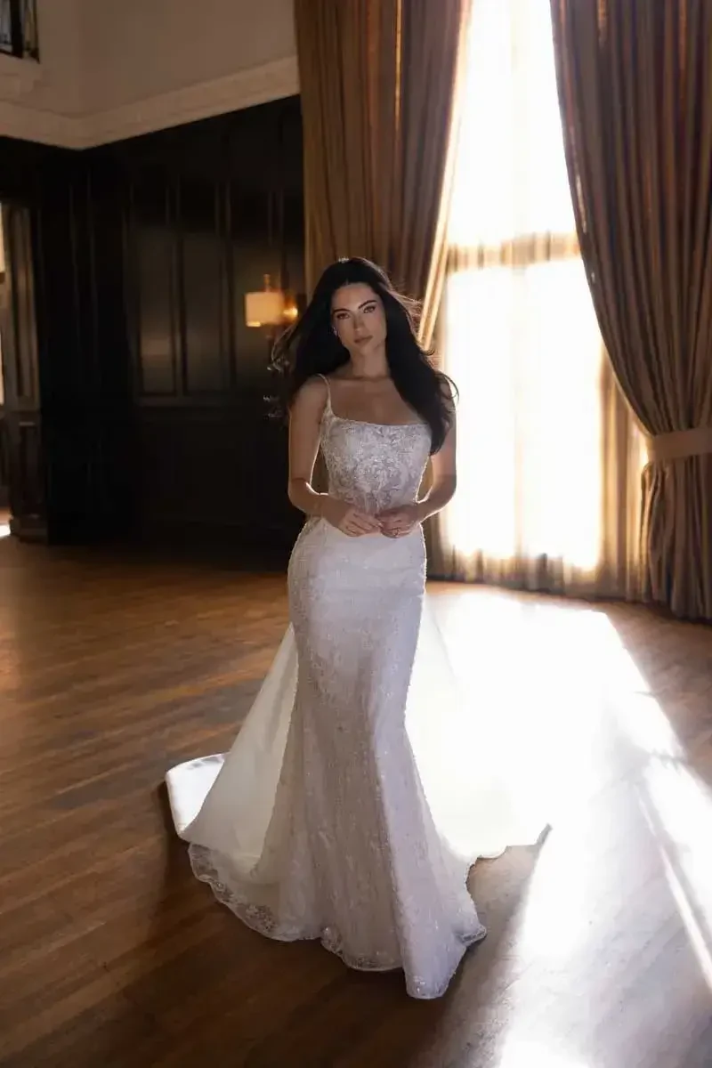 model is wearing a sleeveless open back bridal gown
