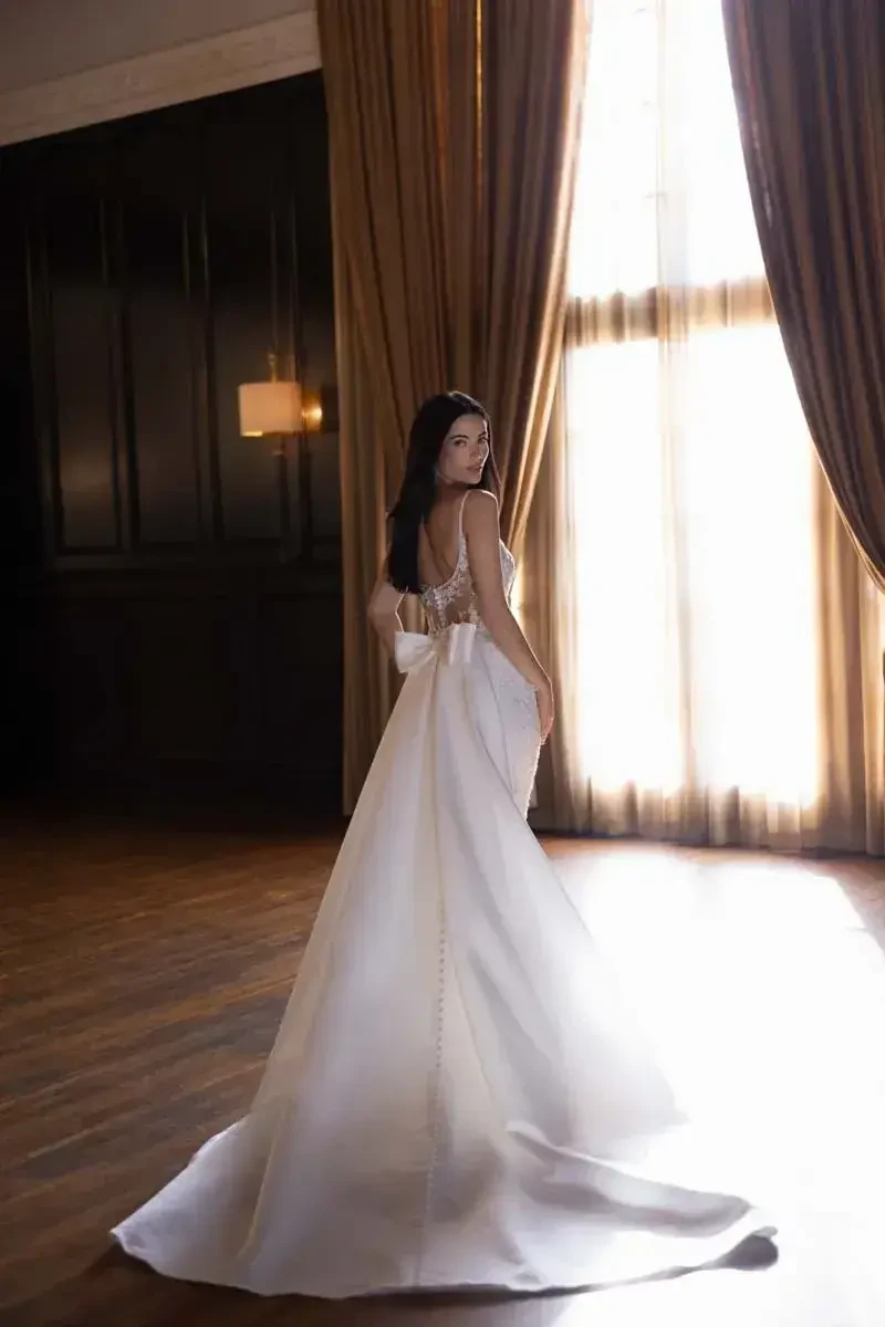 model is wearing a sleeveless open back bridal gown
