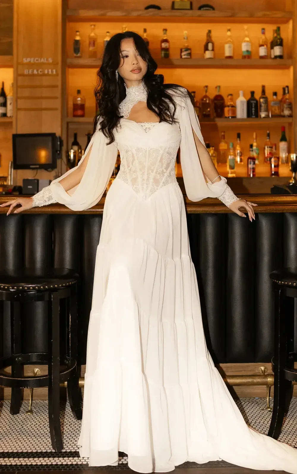 model is wearing a lace boho bridal gown with a jacket