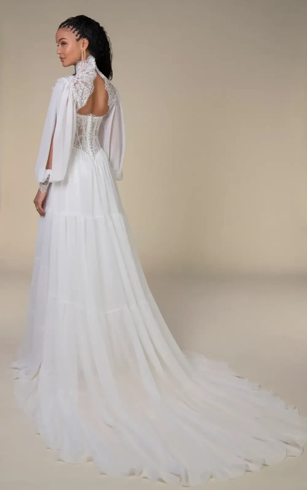 model is wearing a lace boho bridal gown with a jacket