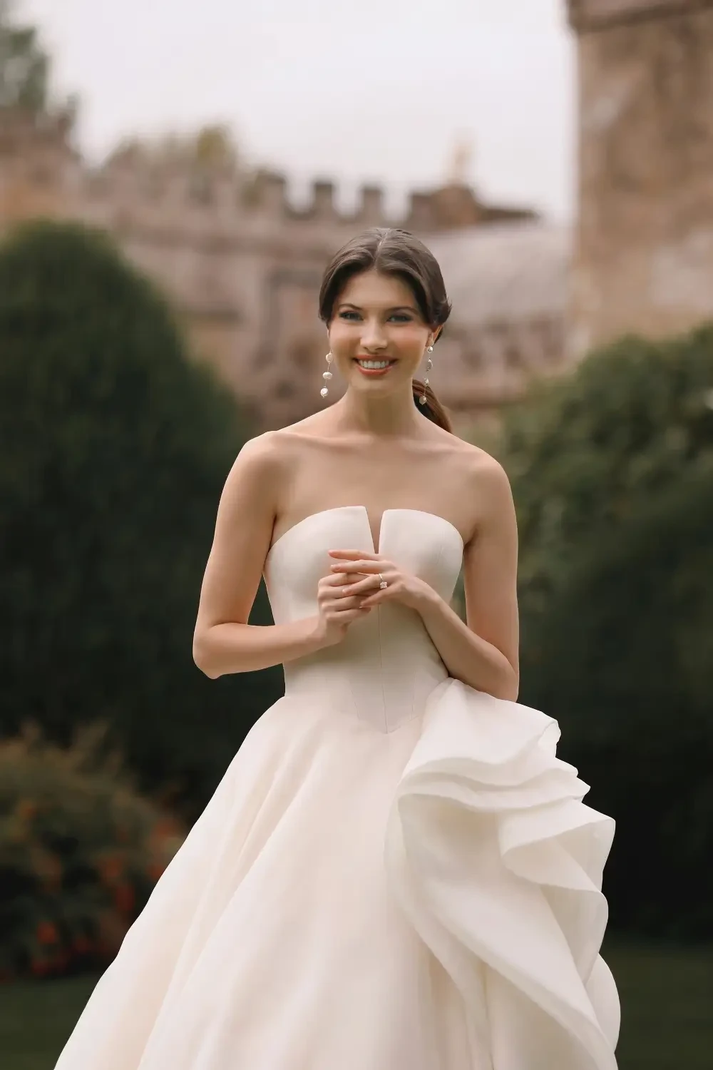 model is wearing a strapless plunging neckline wedding gown 