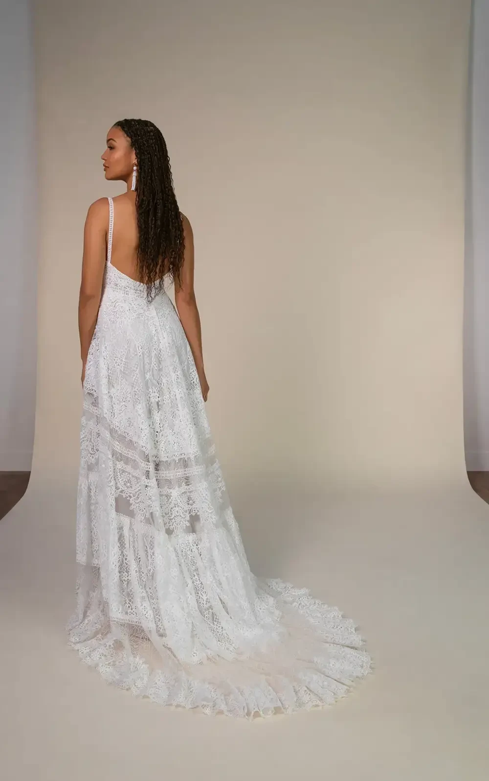 model is wearing a spaghetti strap boho chic bridal gown