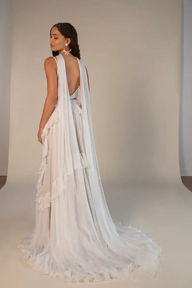 model is wearing a flowy open back bridal gown