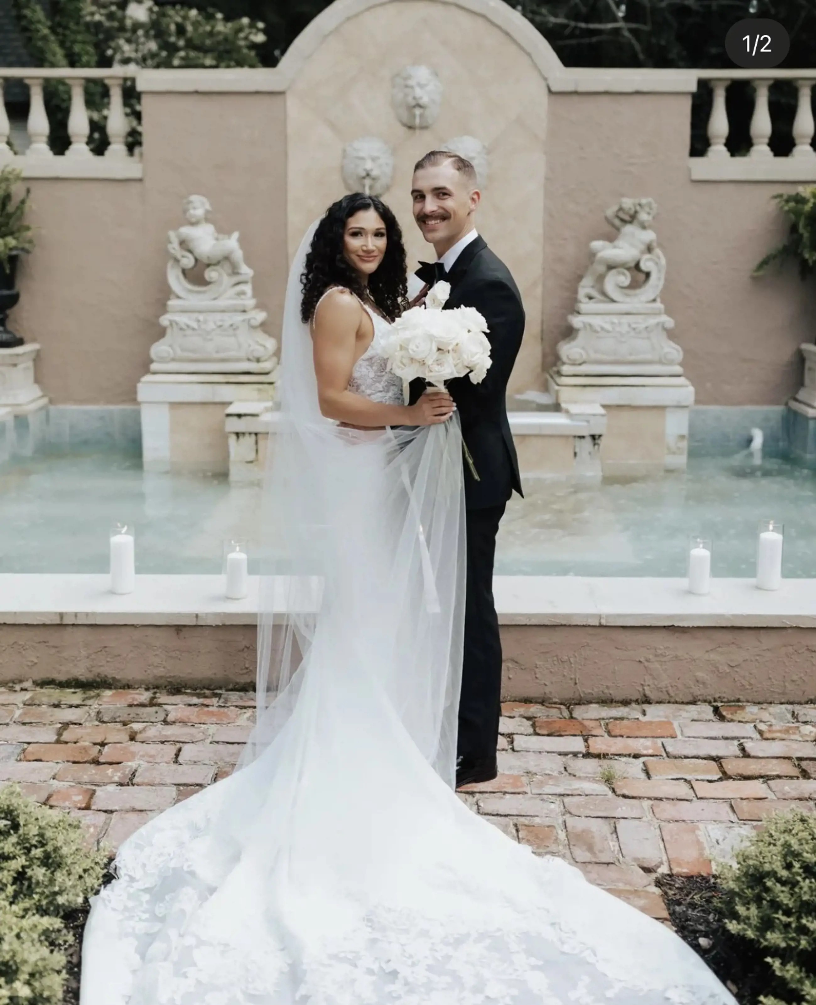 Сouple wearing a white gown and a black suit with a flowers