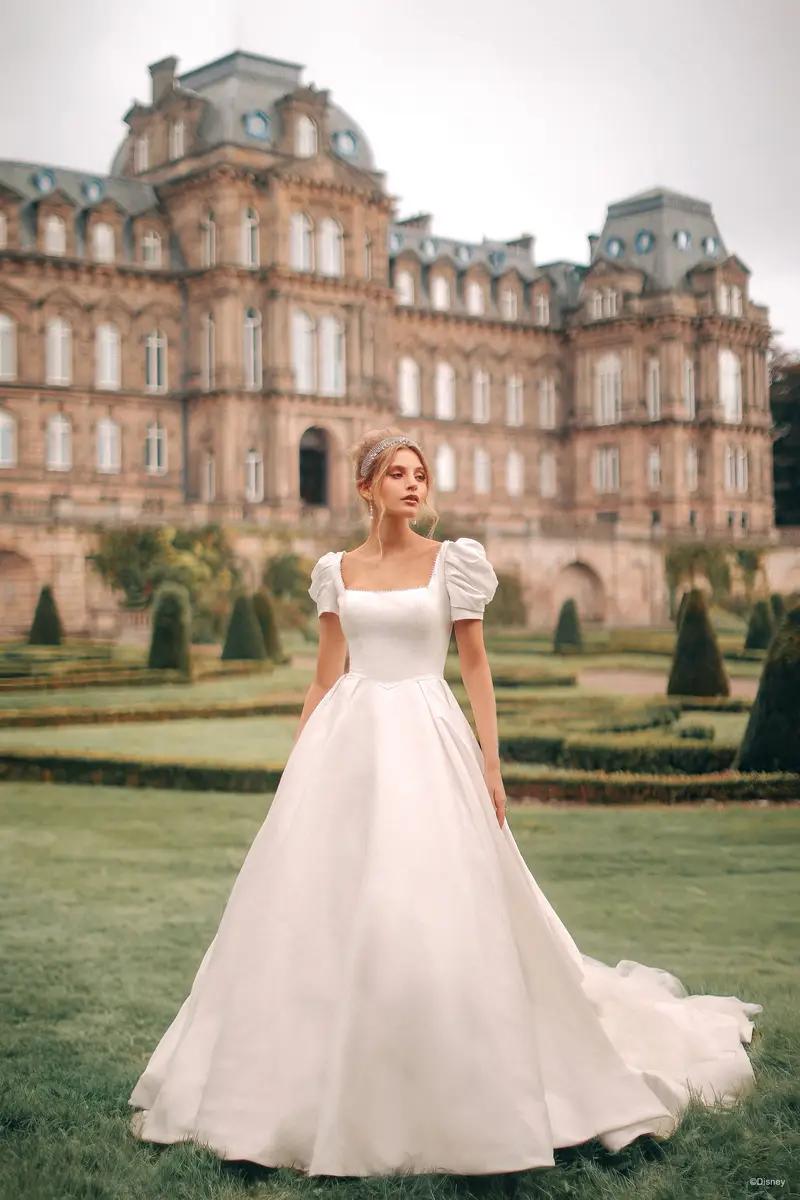Model wearing a white gown in front of castle